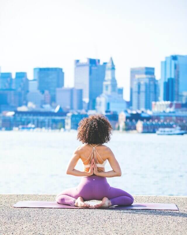 Yoga in city in purple athleisurewear