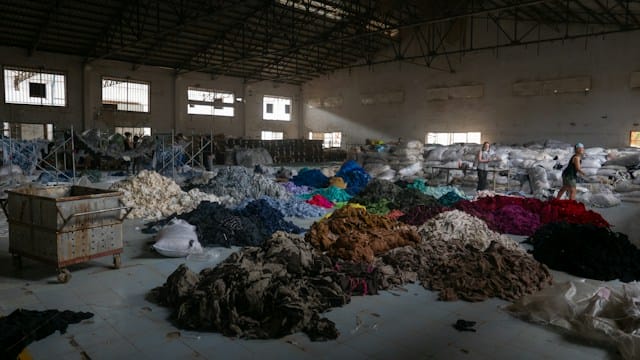 is hollister fast fashion? Piles of clothes in a warehouse