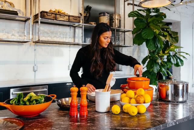 A well-dressed woman preparing a healthy dish, Image by Jason Briscoe from Unsplash 