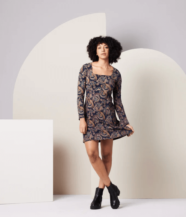 A model posing and showcasing KNOWN SUPPLY's patterned dress