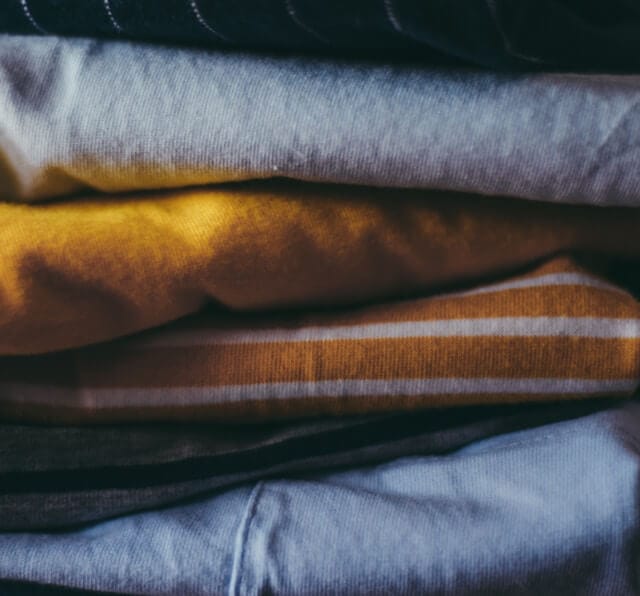A stack of clothes, Image by Zoe from Unsplash