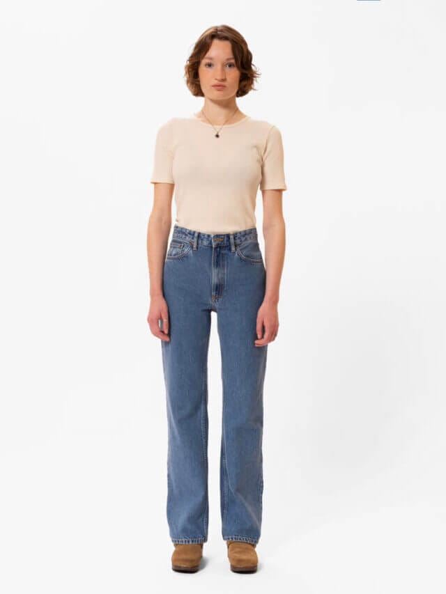 A woman with short hair wearing a loose-fit jeans with a wide leg and high waist jeans made from organic cotton by Nudie.