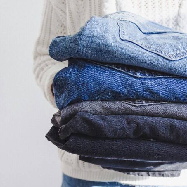 Pile of denim jeans in range of colours