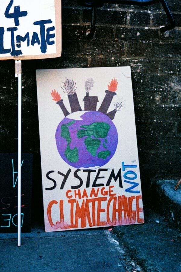 sign says system change not climate change
