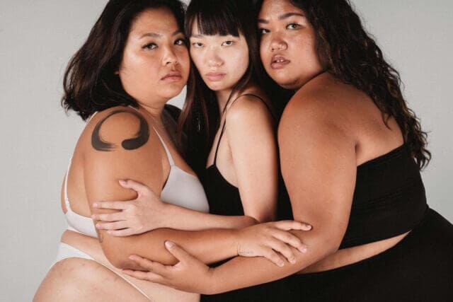 Three women united in a big hug.