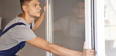 photo of man replacing windows