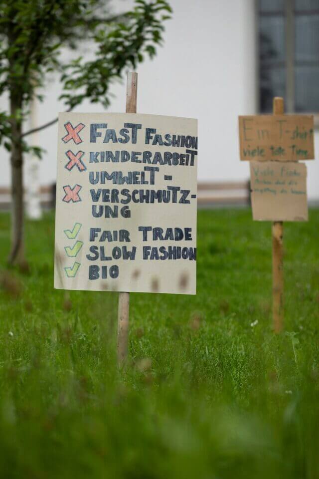 A protest sign that is against fast fashion and for fair trade slow fashion. 