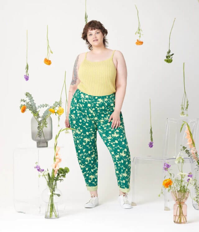 A plus-size model wearing a yellow top with printed trousers from Known Supply.