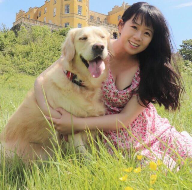 JulieMay founder sitting in a garden with her Labrador dog Mipi.