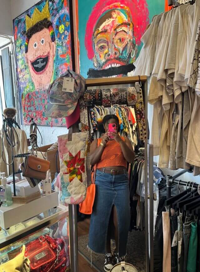 Woman taking a selfie in a thrift shop.