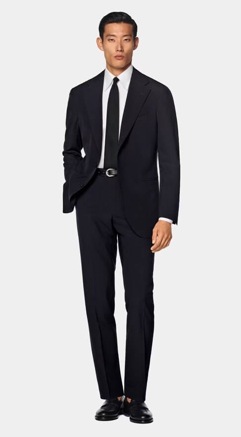 Asian male model wearing a Suit Supply suit, showcasing personalized sustainable suits for all body types.
