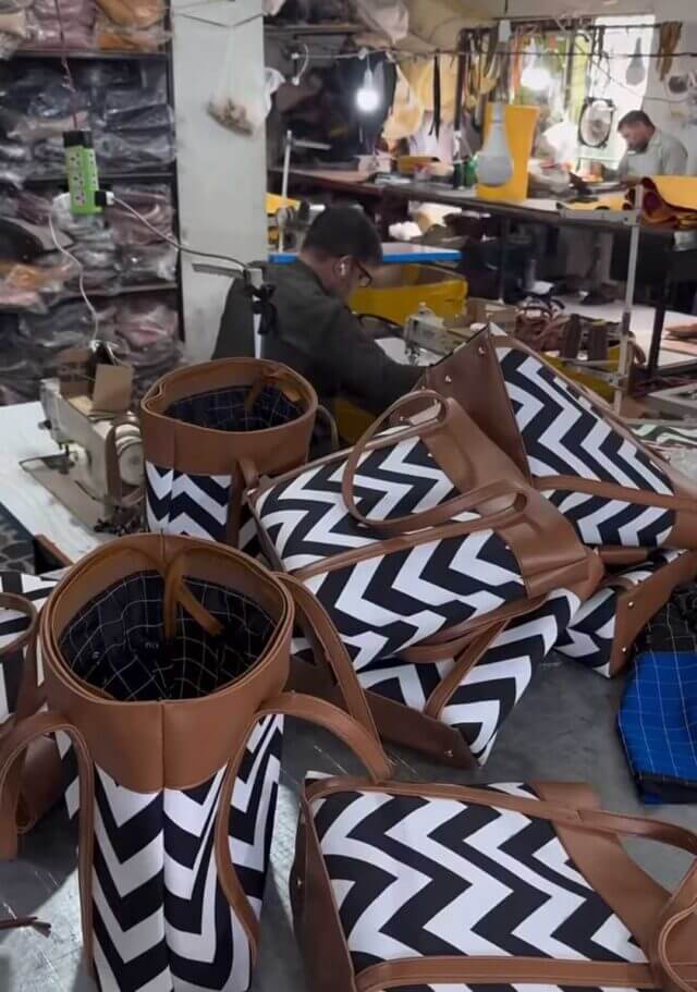 Image Description: Image of a bag manufacturing factory in Pakistan where are crammed in a dark room to stitch bags in bulk