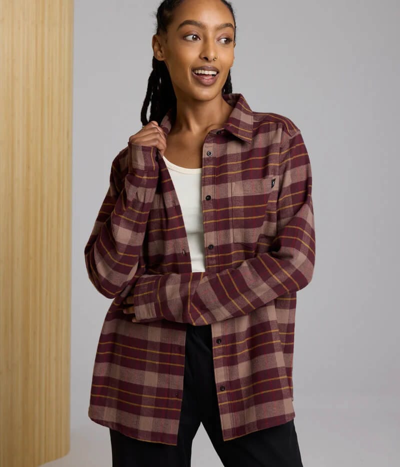 A young woman is smiling, showing her unisex flannel fudge.